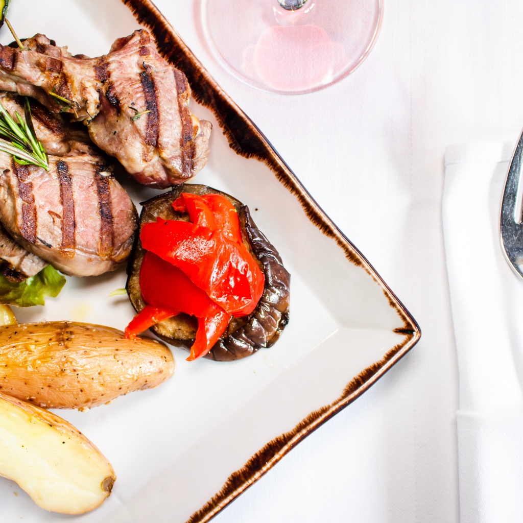 Свиные ребрышки с овощами на столе 