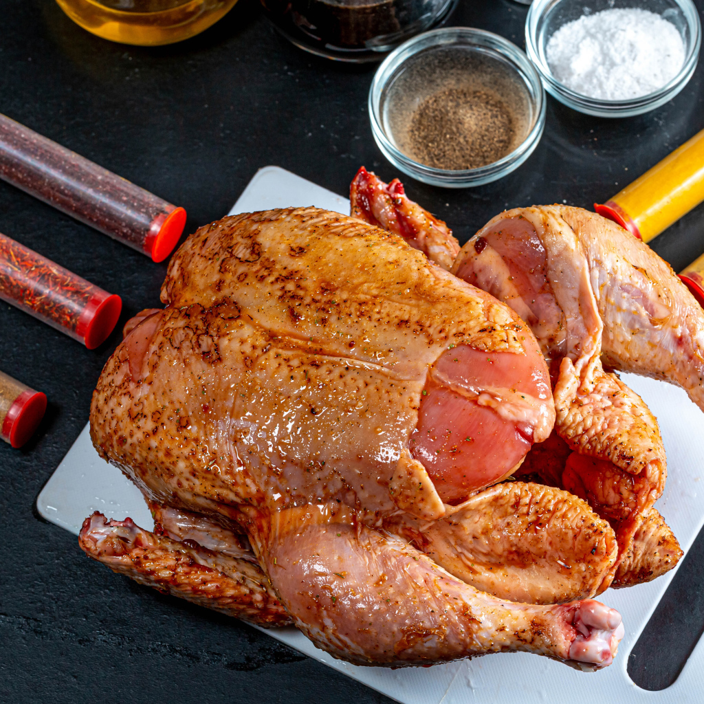 Сырая курица со специями на столе 