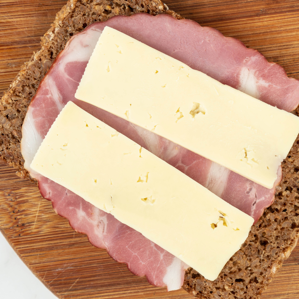 Бутерброд с ветчиной и сыром на доске 