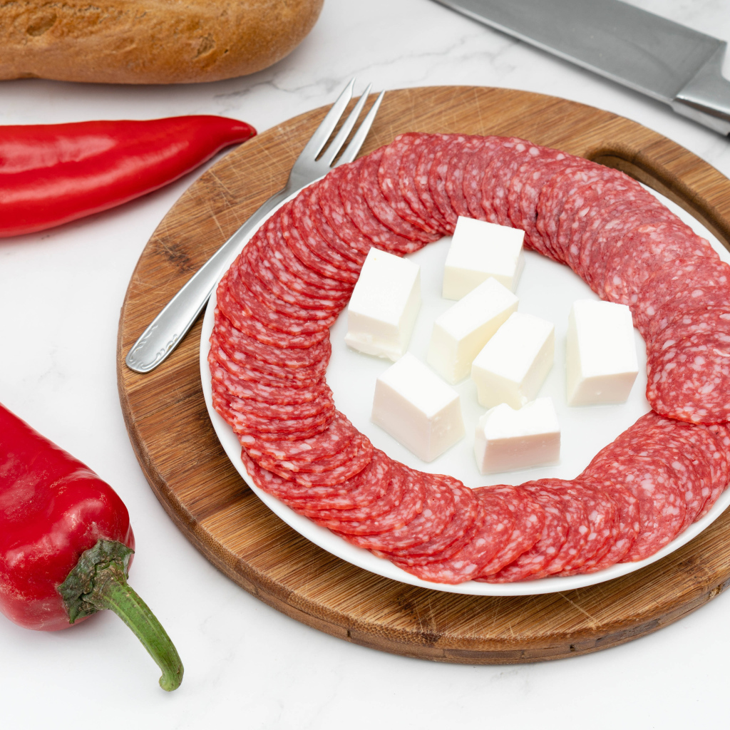 Колбаса с сыром на столе с красным сладким перцем