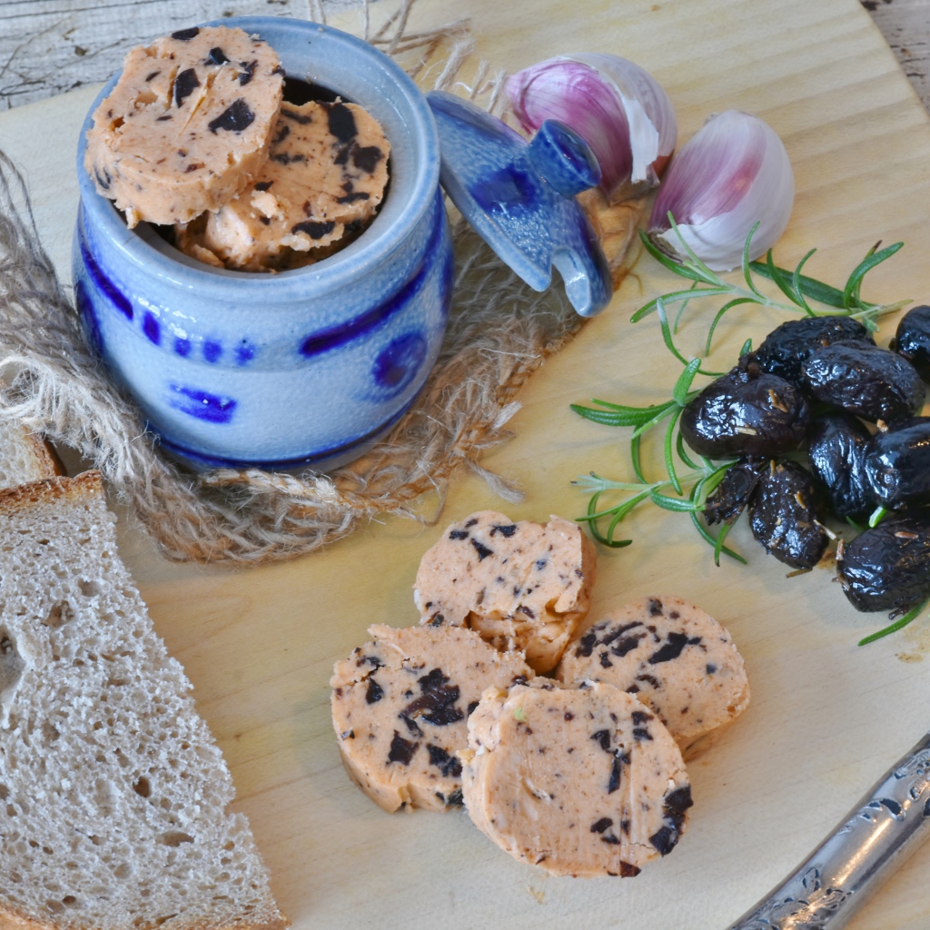 Колбаса с маслинами на столе с хлебом и чесноком