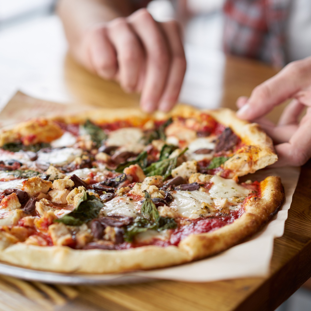 Мужчина в кафе ест вкусную горячую пиццу 