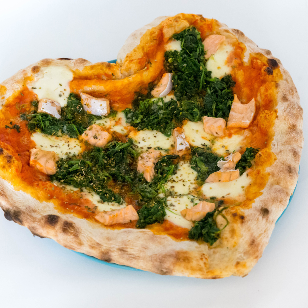 Пицца с рыбой и сыром в форме сердца на белом фоне