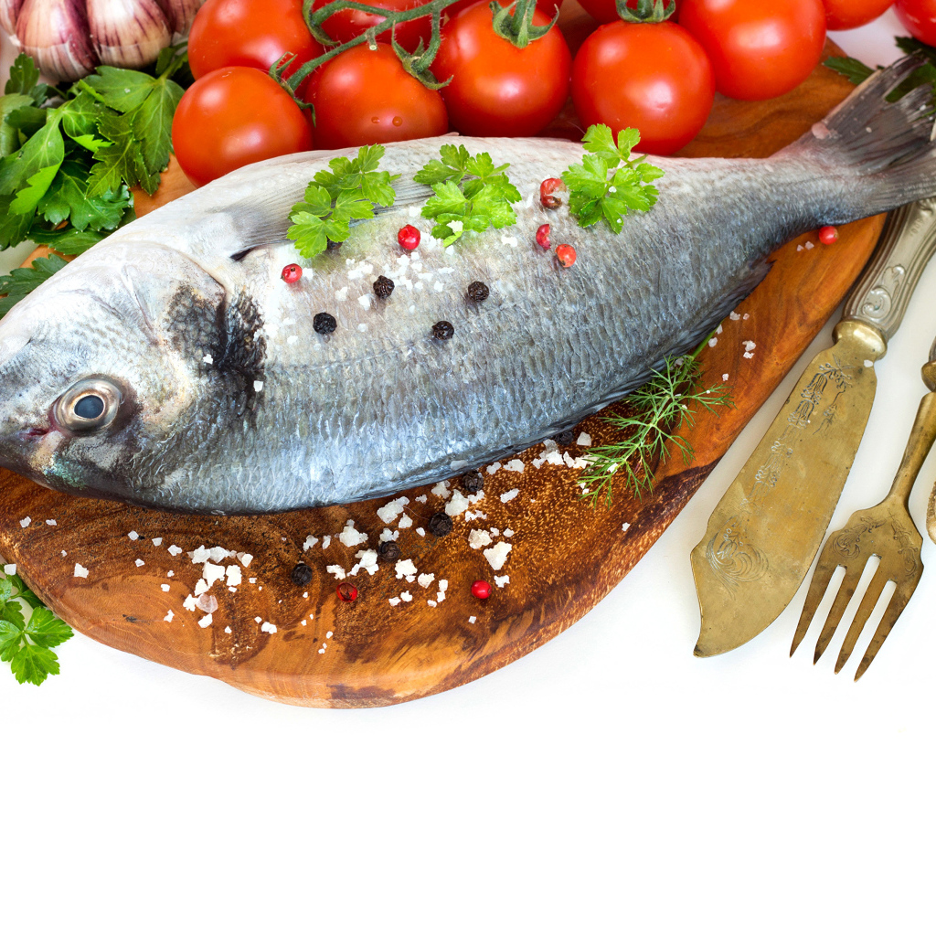 Сырая рыба на столе с маслом и помидорами 