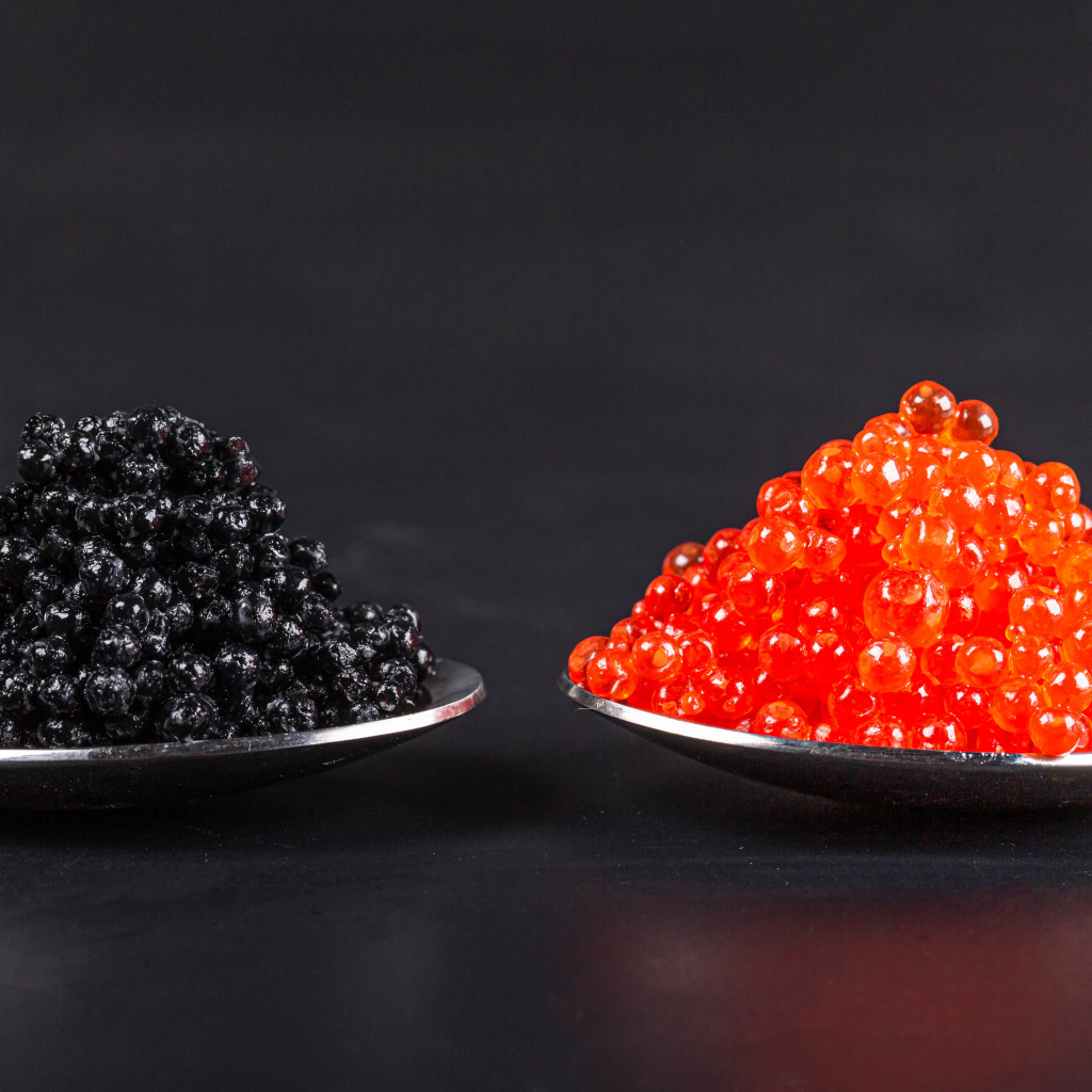 Красная и черная икра на ложках на сером фоне