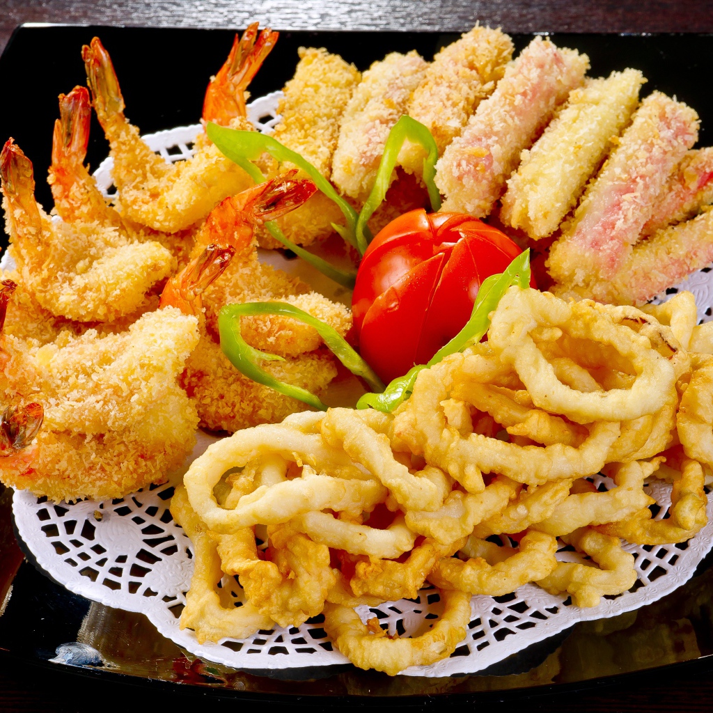 Морепродукты в кляре на тарелке с помидором