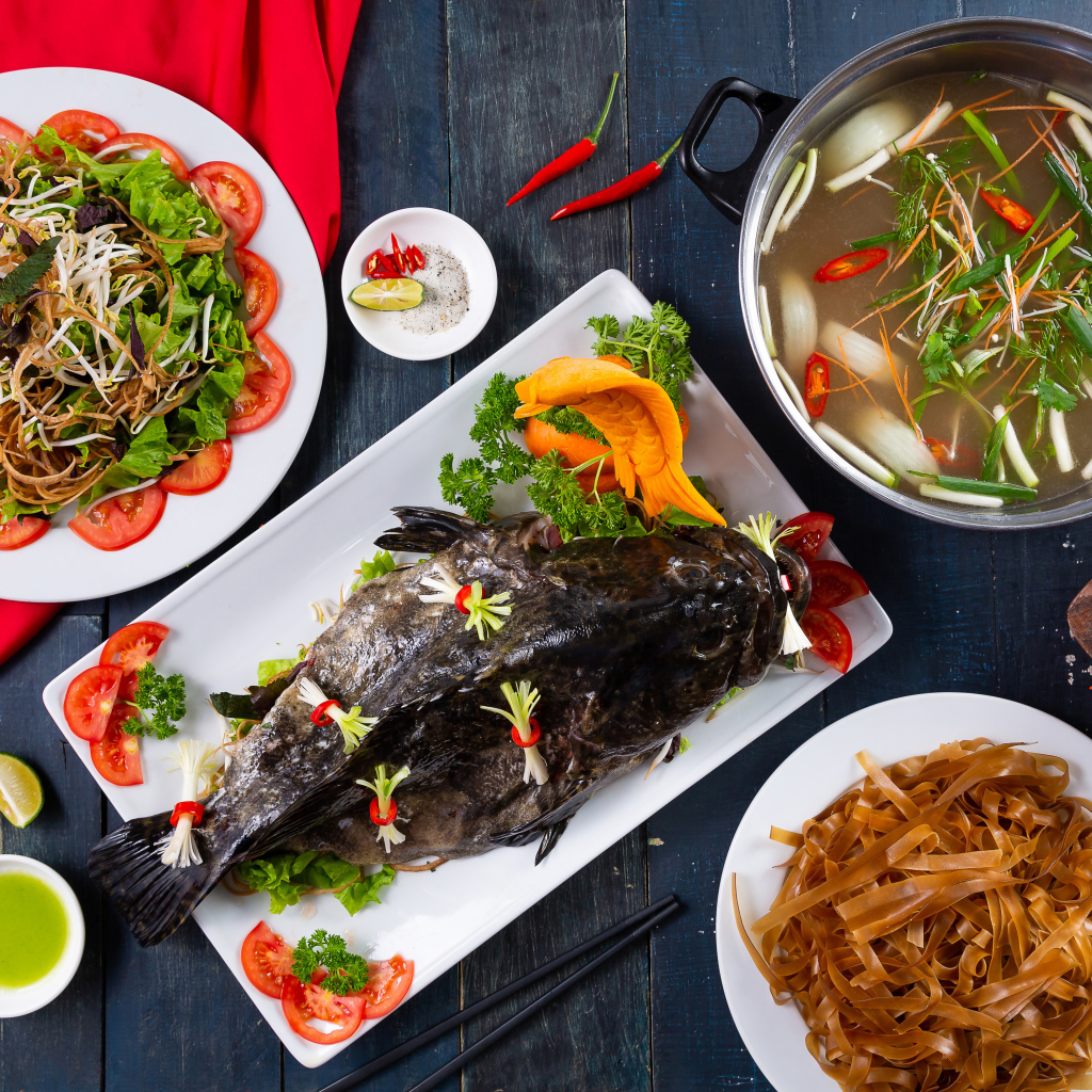 Фаршированная рыба на столе с овощами