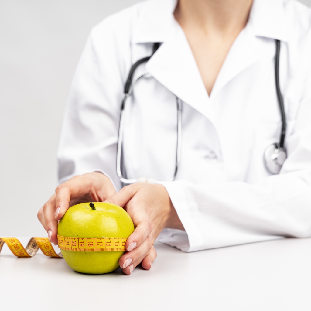 Женщина врач измеряет яблоко сантиметром 