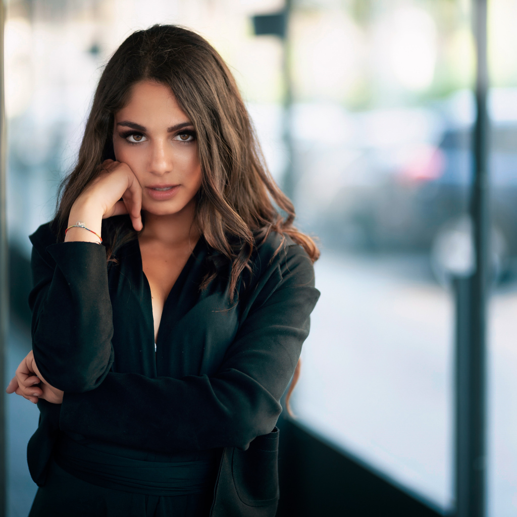 Милая девушка в черном наряде стоит на остановке