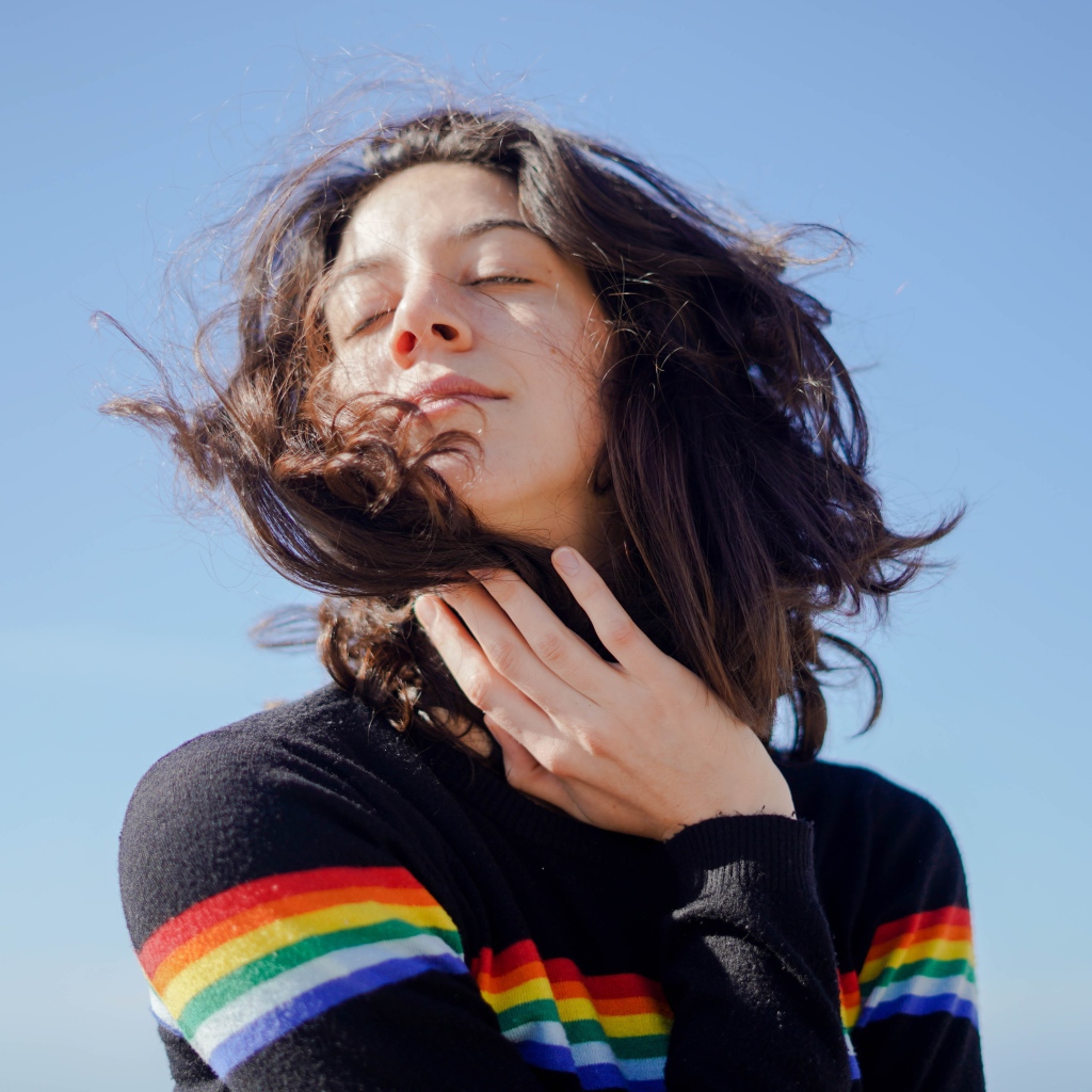 Молодая девушка греет лицо на солнце