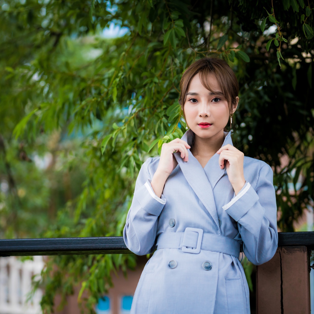 Девушка азиатка в голубом пальто в парке