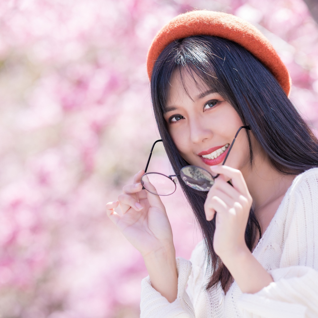 Девушка азиатка в красном берете с очками в руках