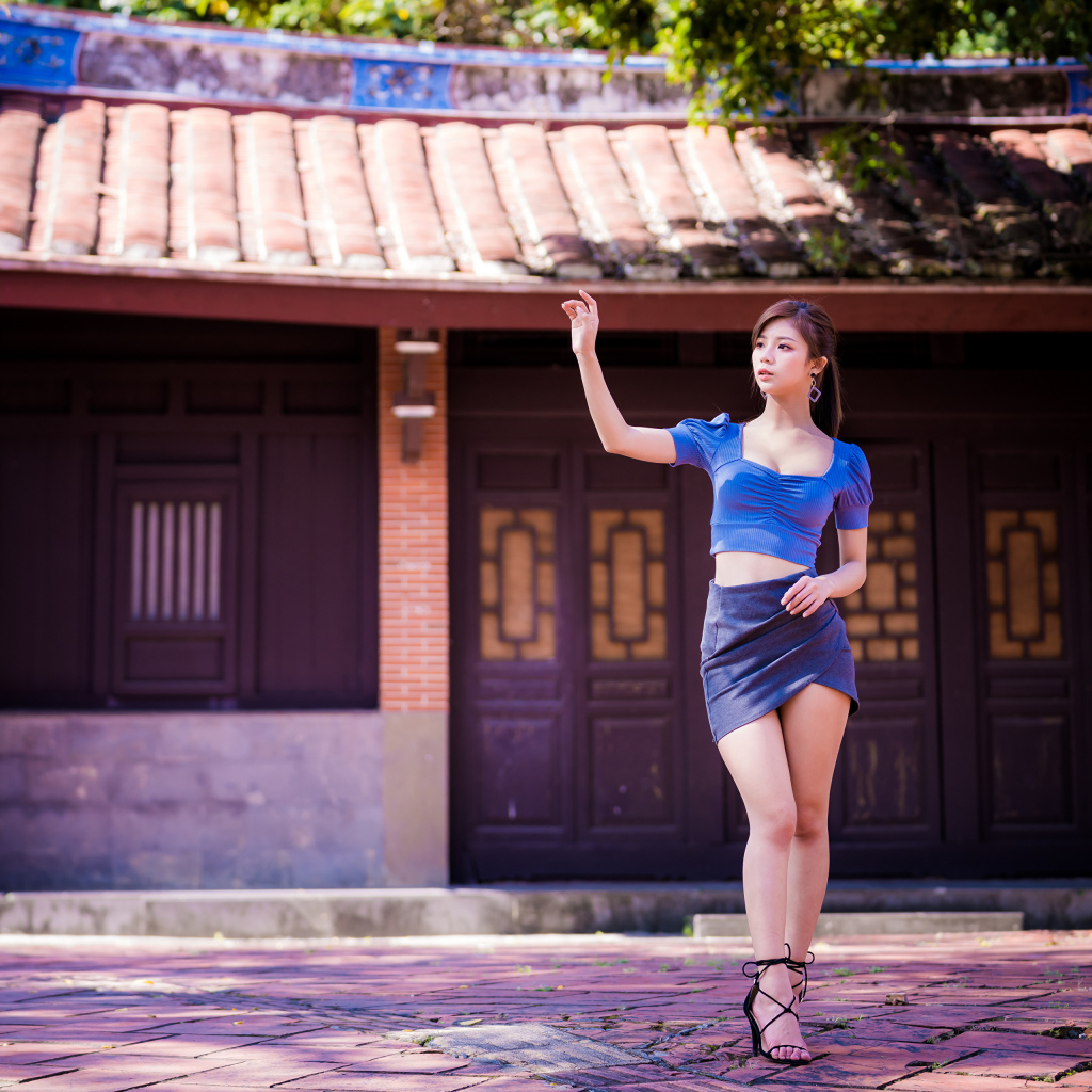Девушка азиатка в короткой юбке у здания 