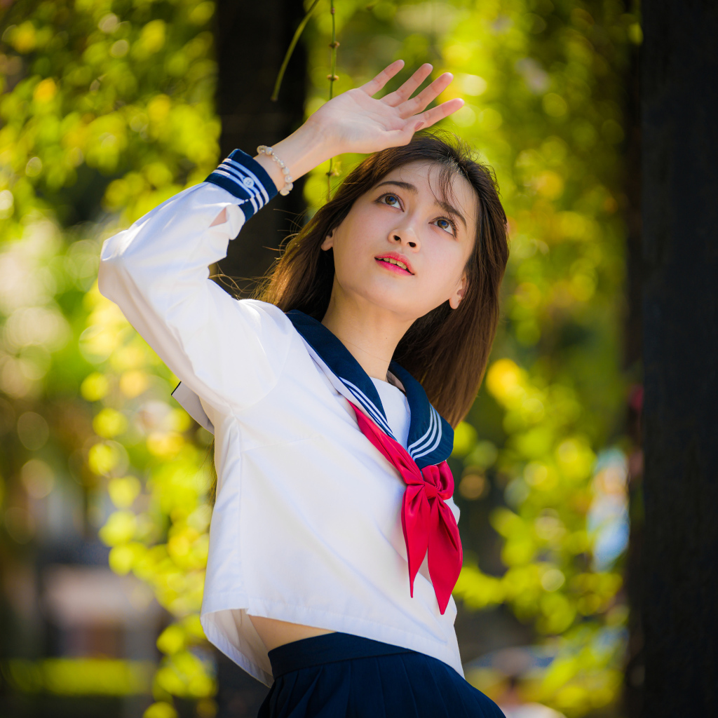 Девушка азиатка в форме с красным галстуком