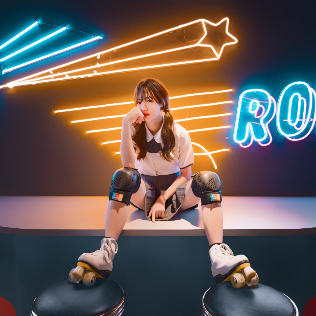 Девушка азиатка сидит в роликах на фоне вывески 