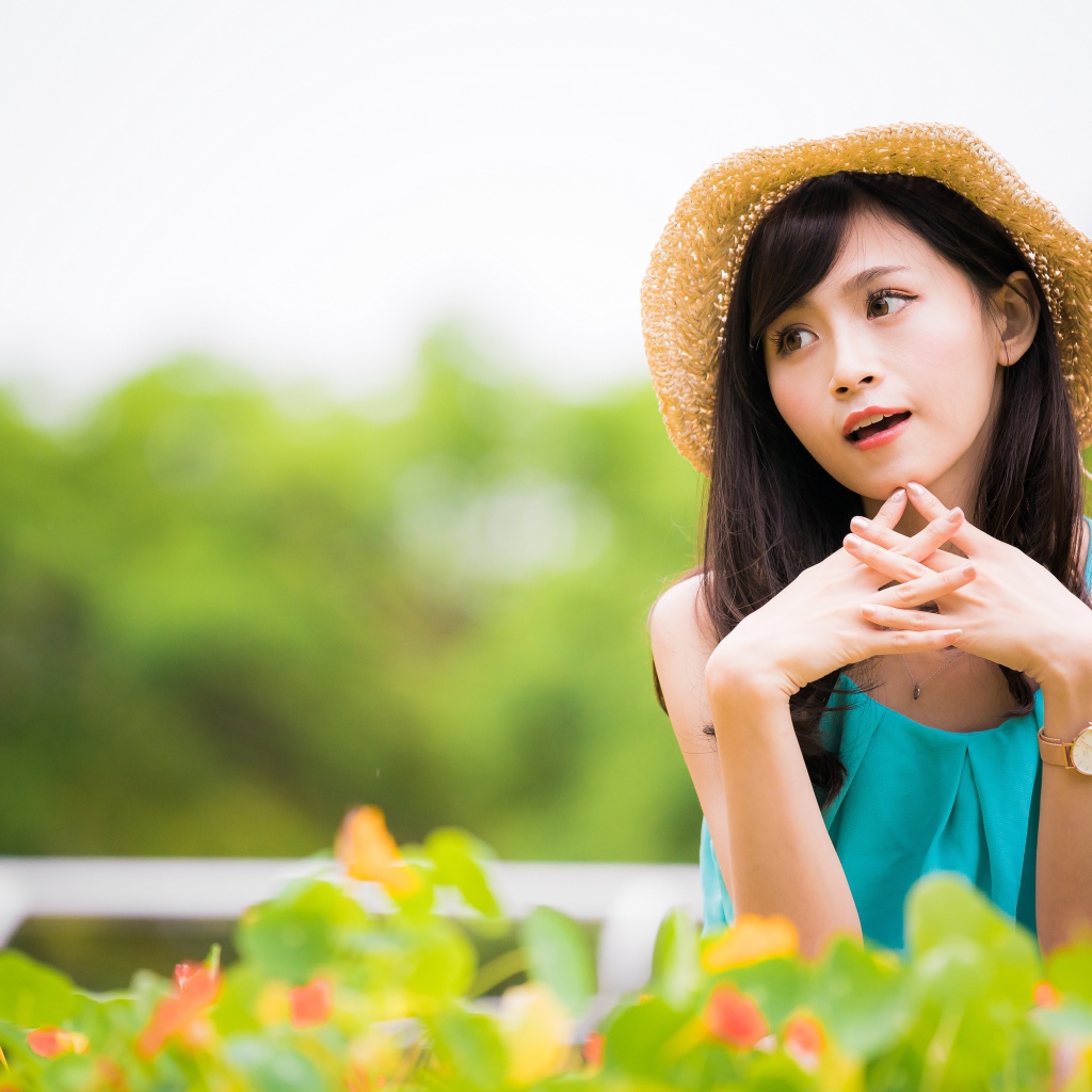 Девушка азиатка с часами на руке в шляпе