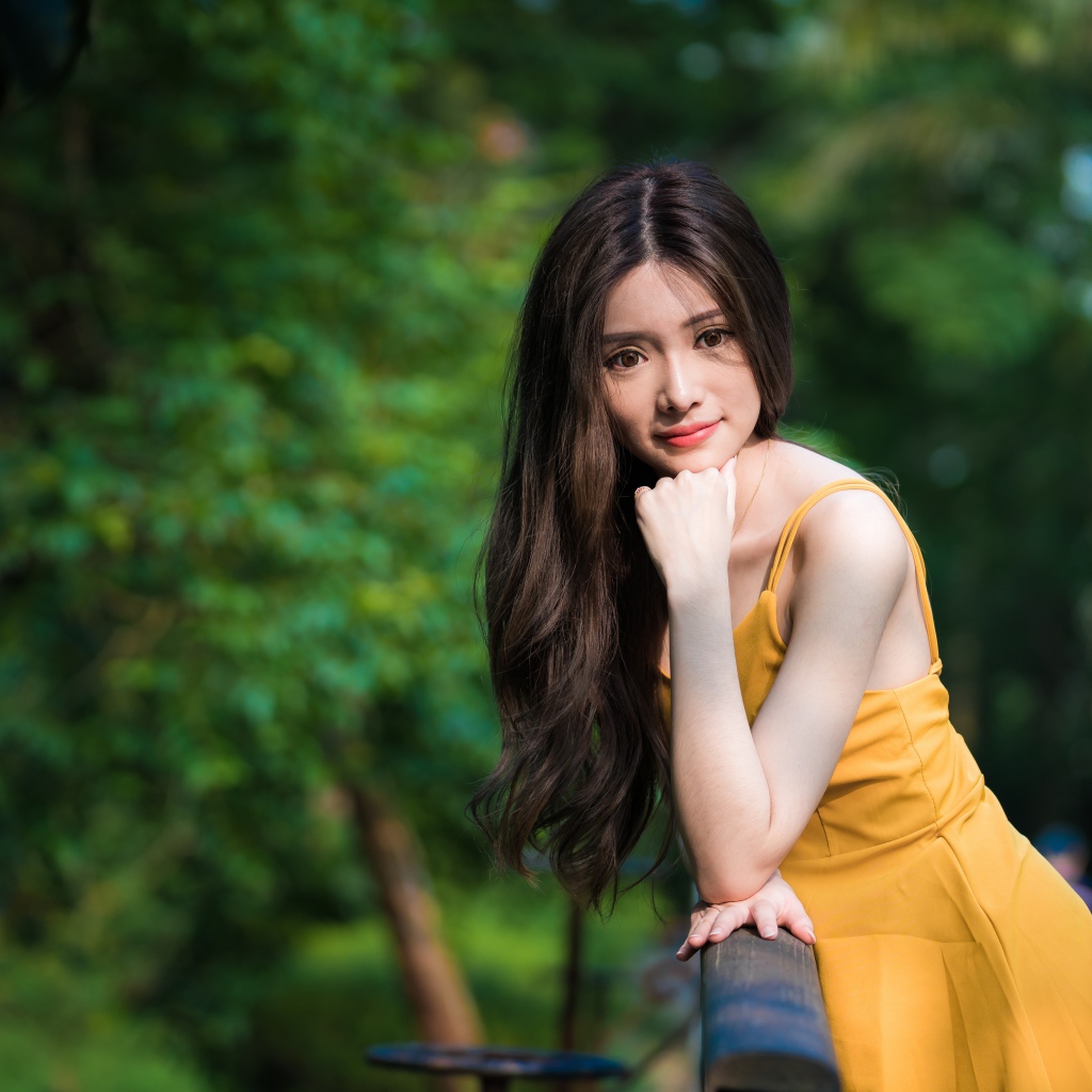 Девушка азиатка с большими карими глазами в желтом платье 