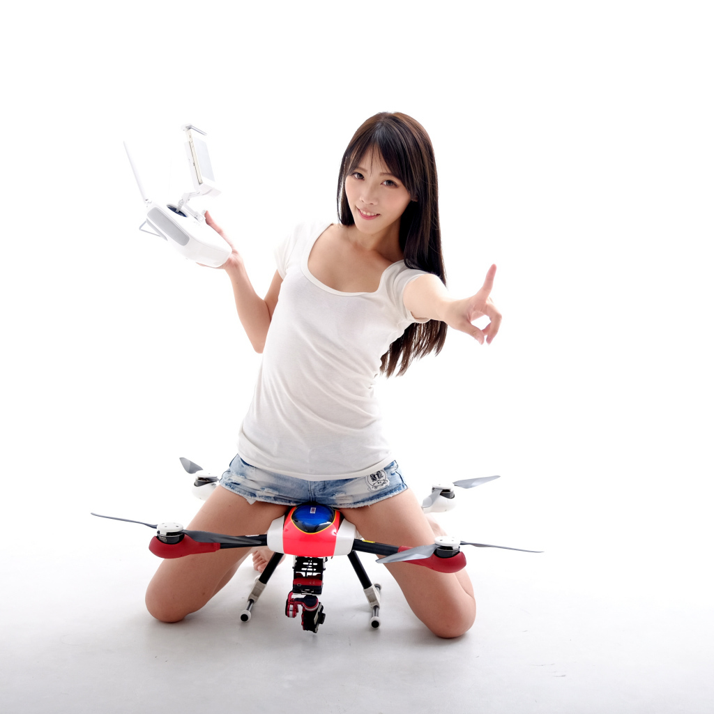 Девушка азиатка с квадрокоптером на белом фоне