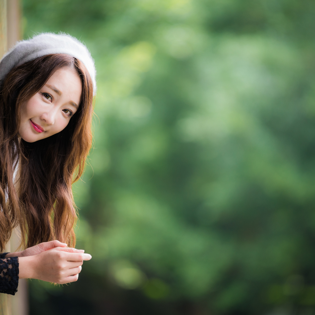 Азиатка в берете выглядывает из окна