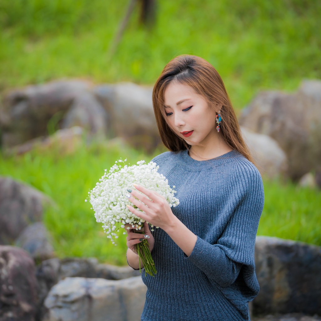 Красивая девушка азиатка держит в руках букет белых цветов