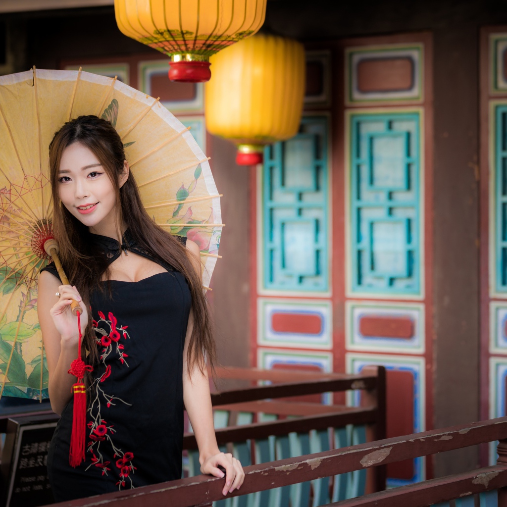Красивая девушка азиатка в черном платье с зонтом