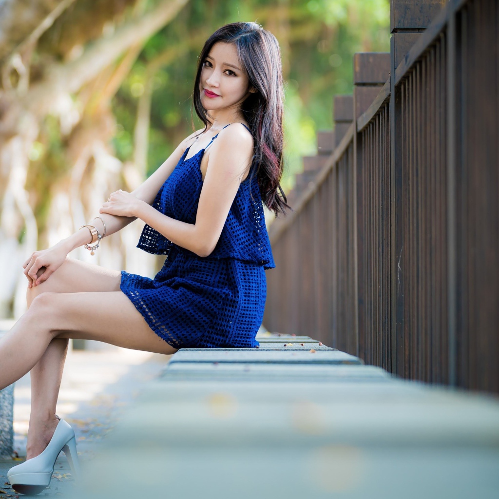 Красивая девушка азиатка в синем платье в парке