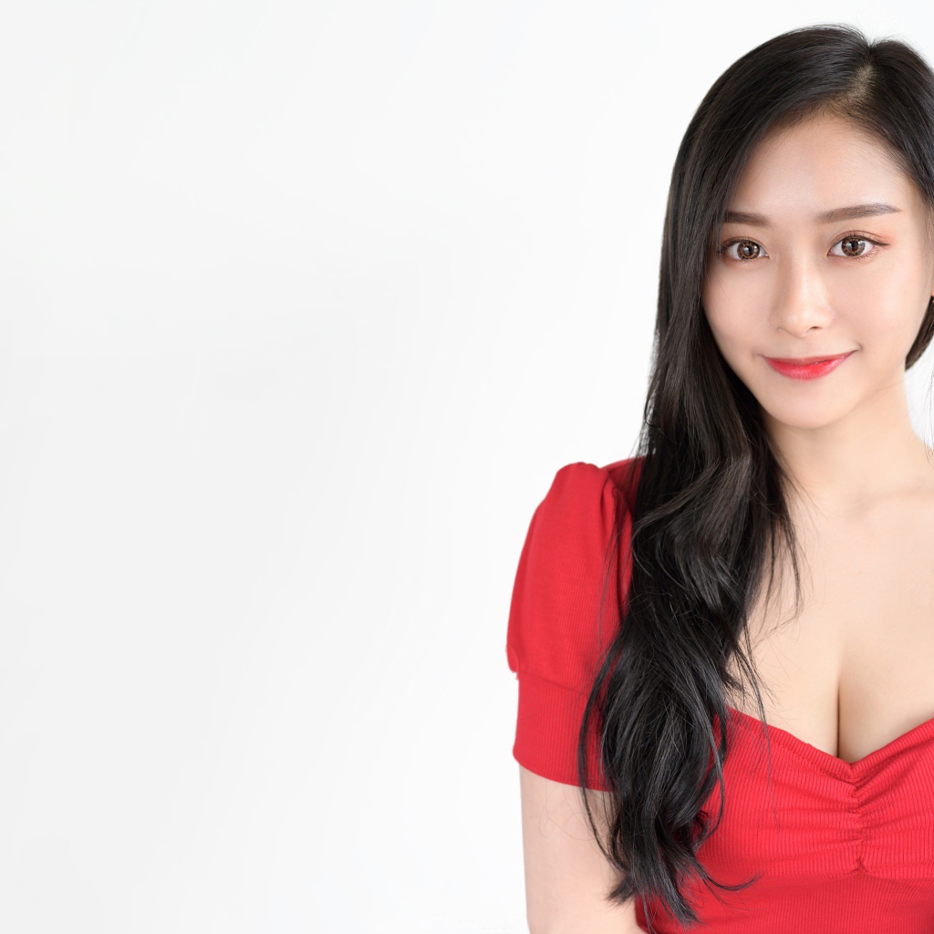 Красивая девушка азиатка в красном платье на белом фоне