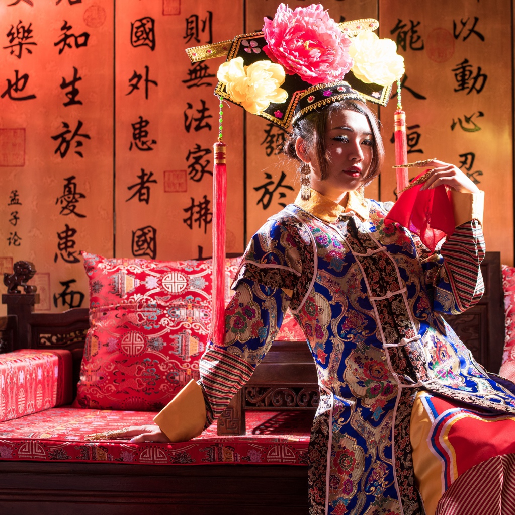 Красивая девушка азиатка в национальном костюме на диване