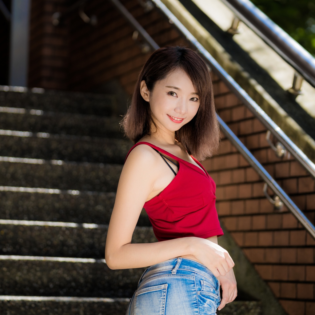 Красивая девушка азиатка стоит на ступенях 