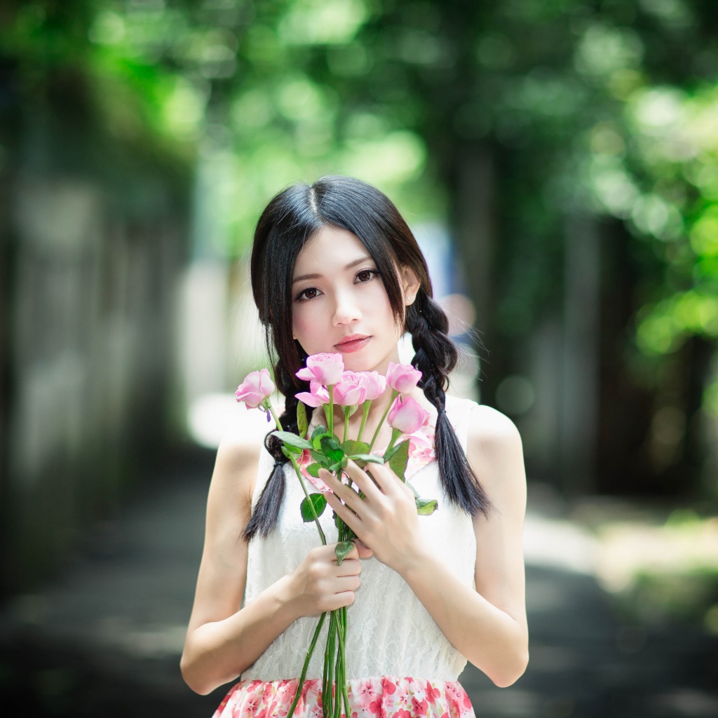 Красивая девушка азиатка в букетом роз в руках
