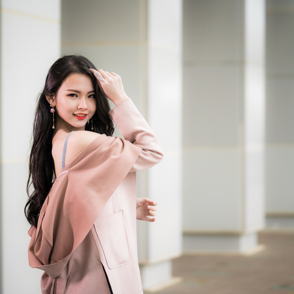 Красивая девушка азиатка с длинными волосами в розовом пальто 