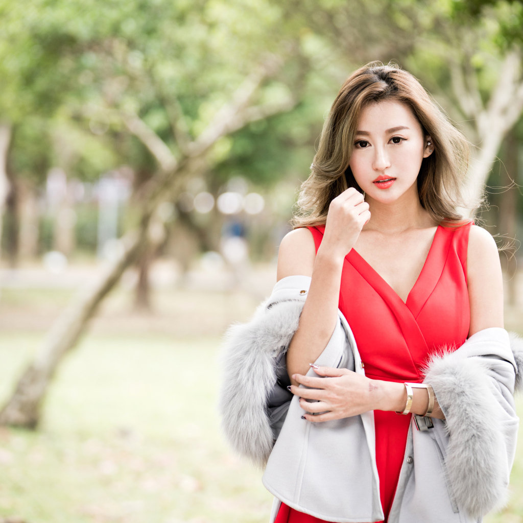 Красивая азиатка в красном платье в парке