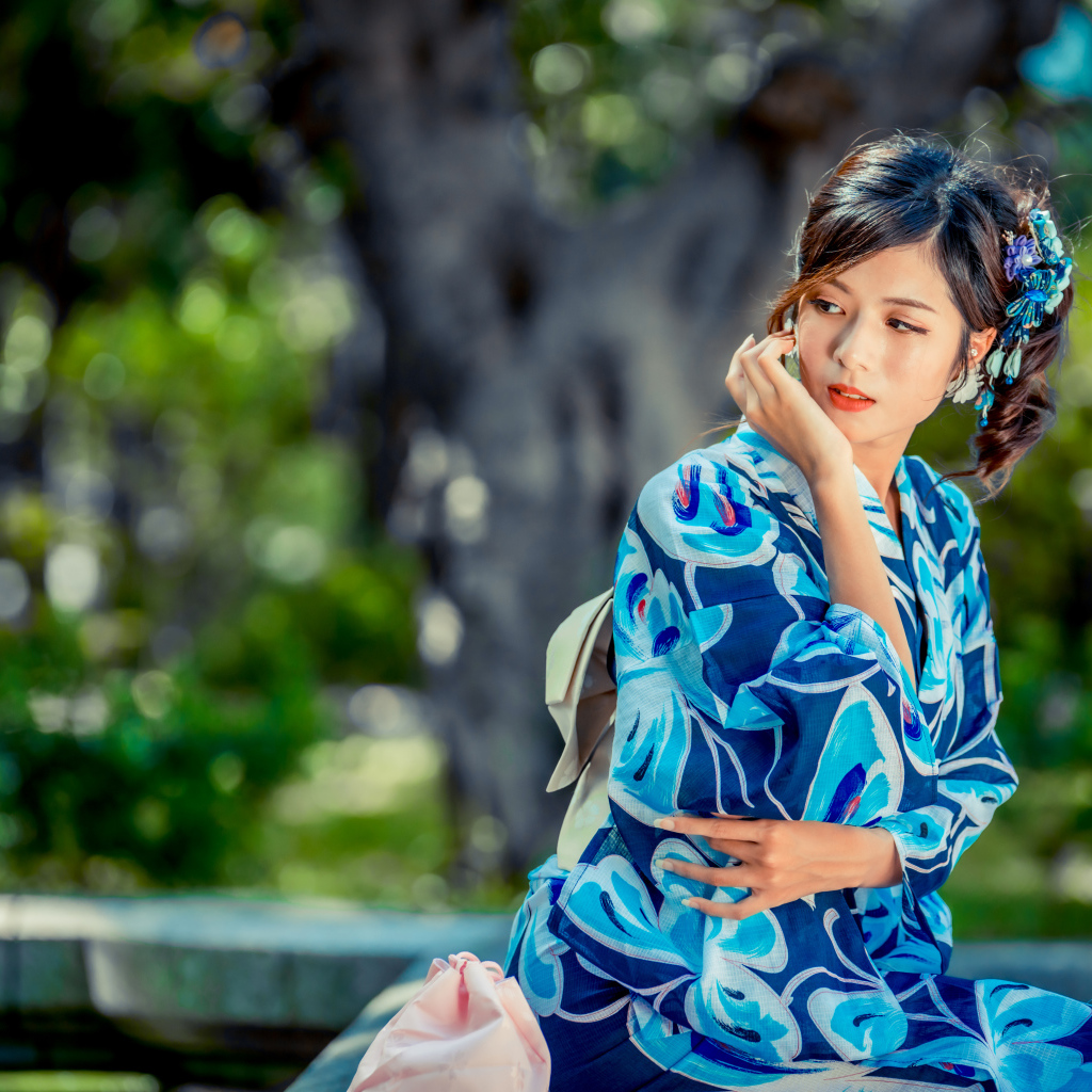 Красивая азиатка в разноцветном кимоно в парке