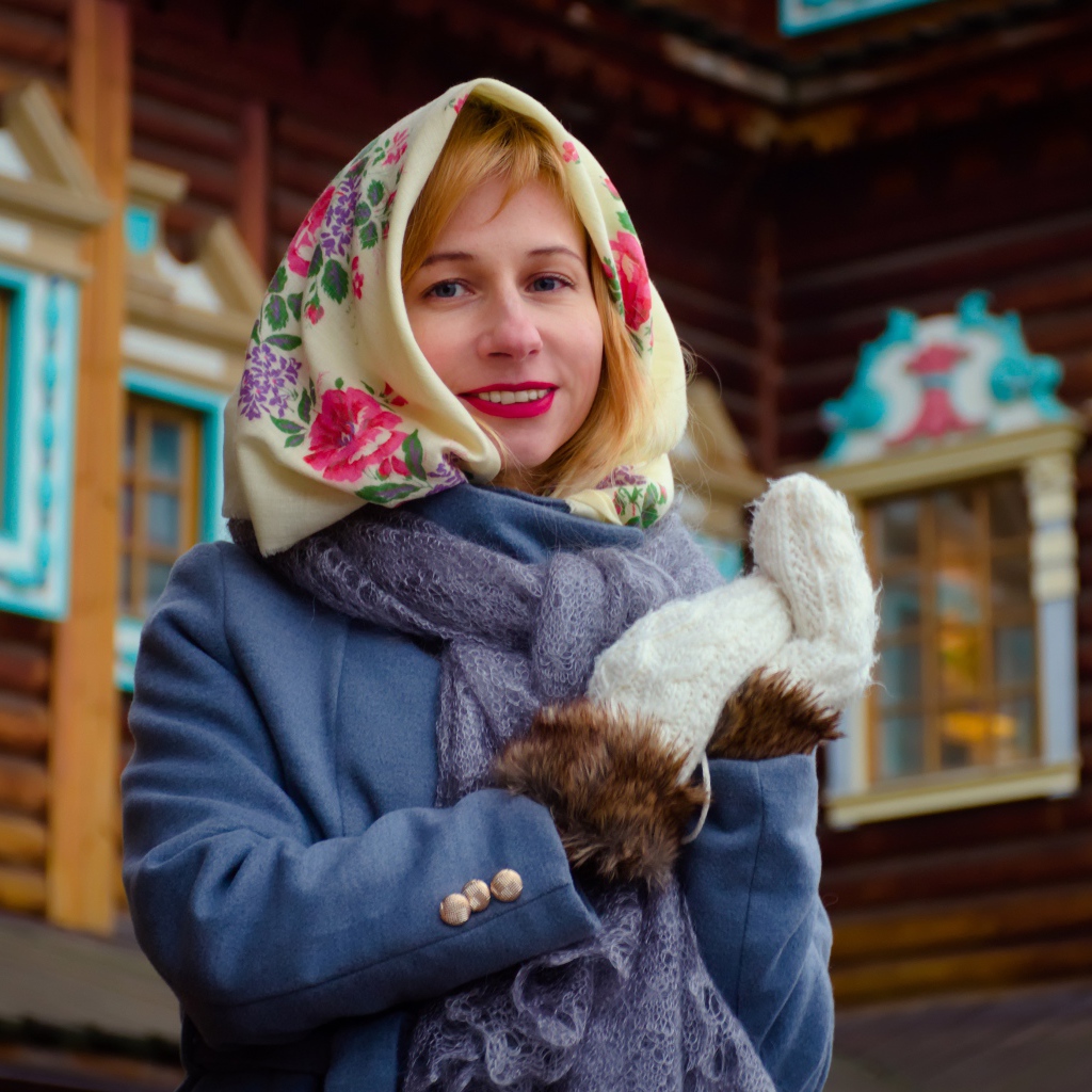 Красивая русская женщина в платке стоит у дома