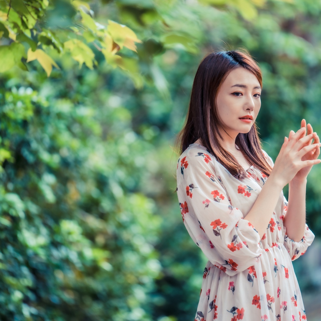 Красивая девушка азиатка в платье в парке