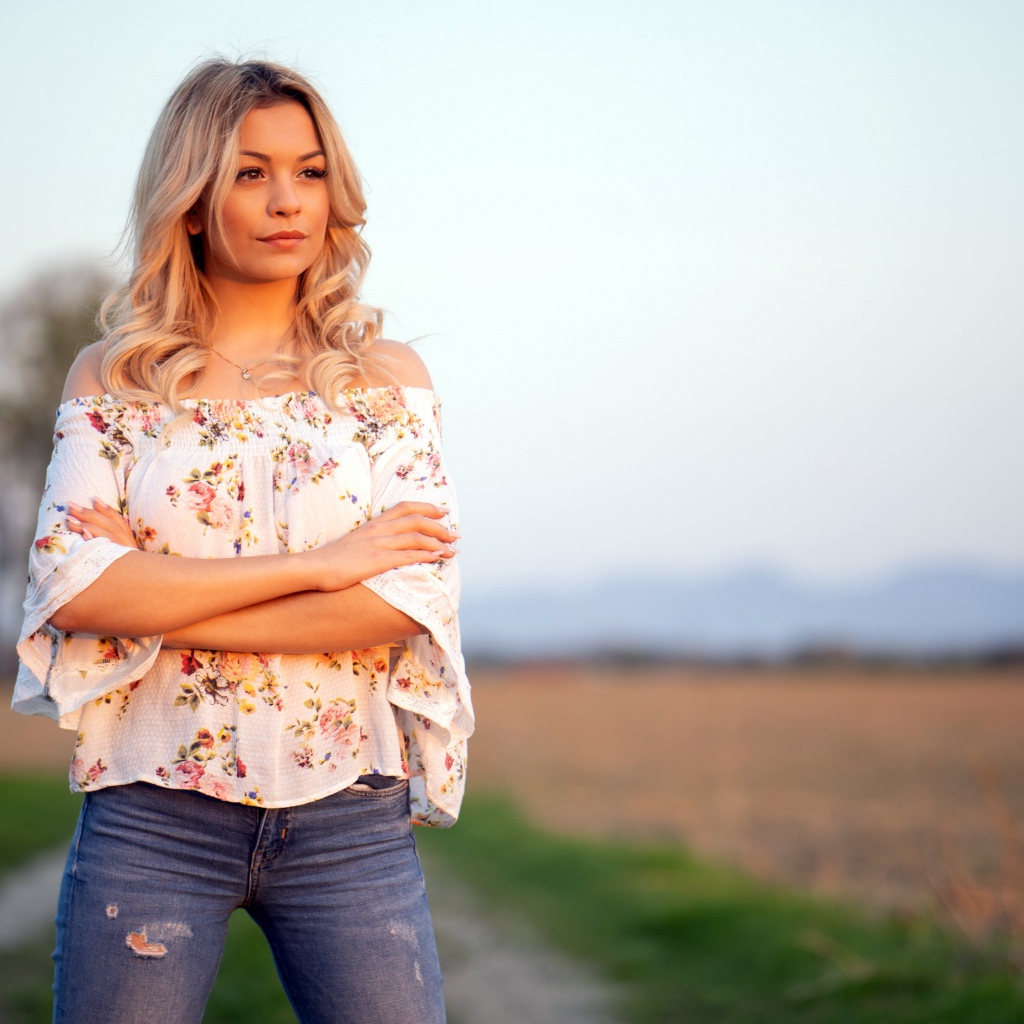 Красивая девушка блондинка в джинсах в поле