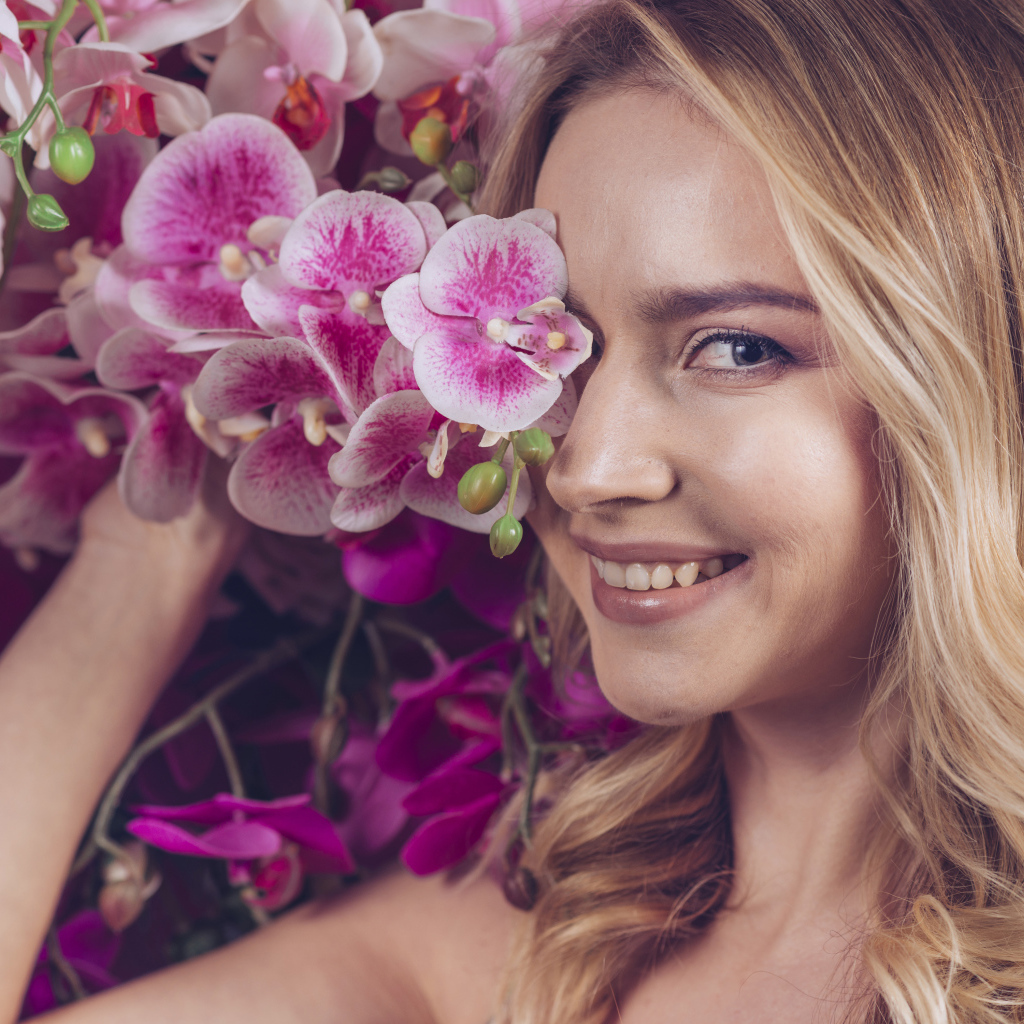 Красивая девушка блондинка с цветами орхидеи