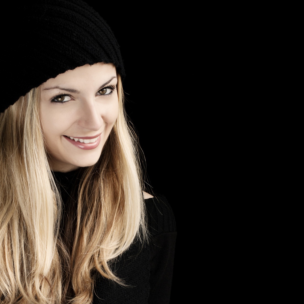 Красивая блондинка в шапке на черном фоне