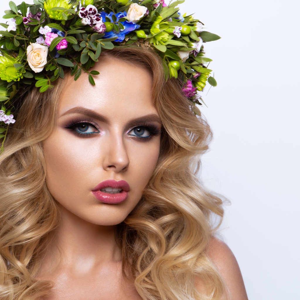 Красивая блондинка с венком из живых цветов на белом фоне
