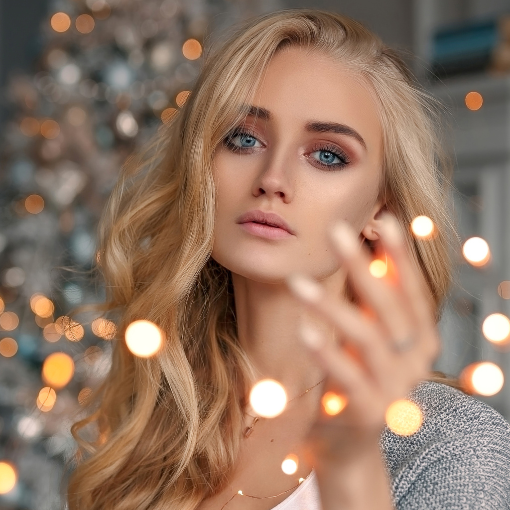 Красивая голубоглазая блондинка с гирляндой в руке