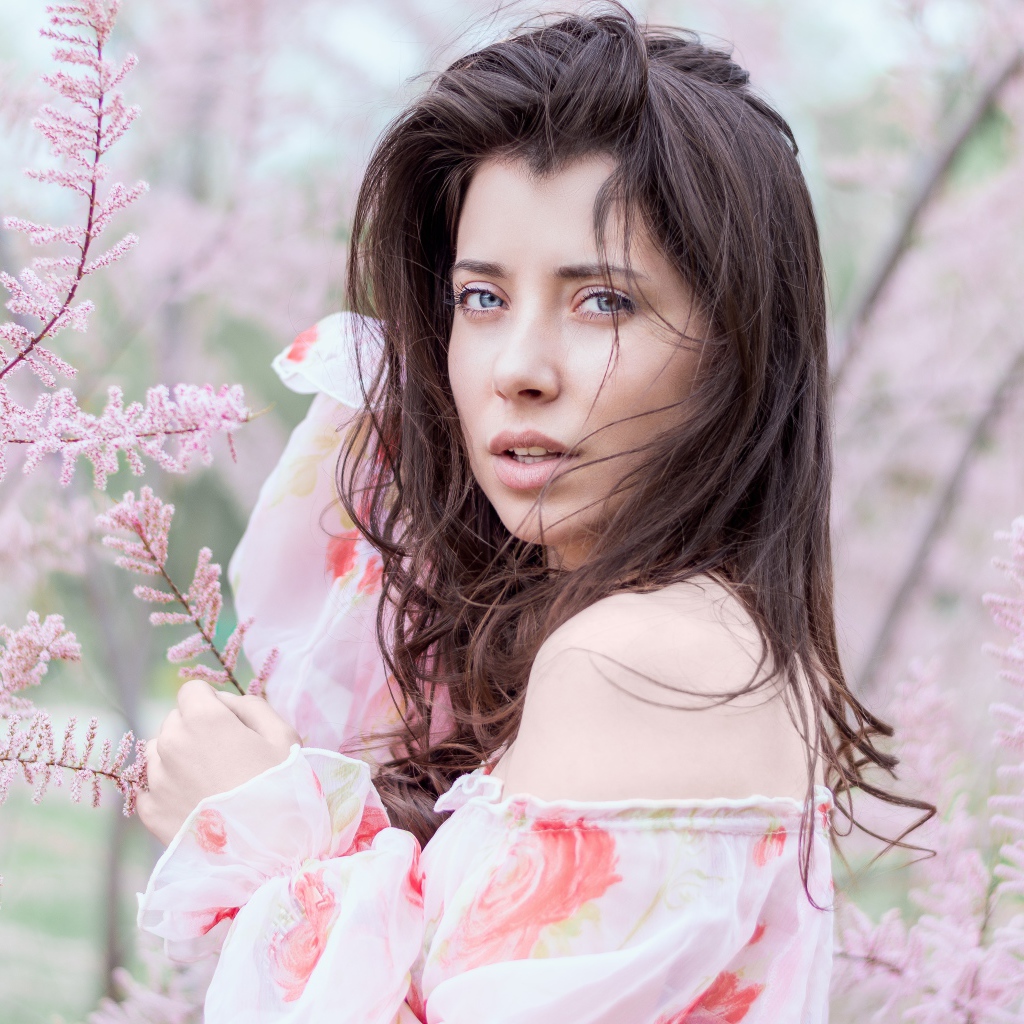 Красивая голубоглазая девушка в розовых зарослях 