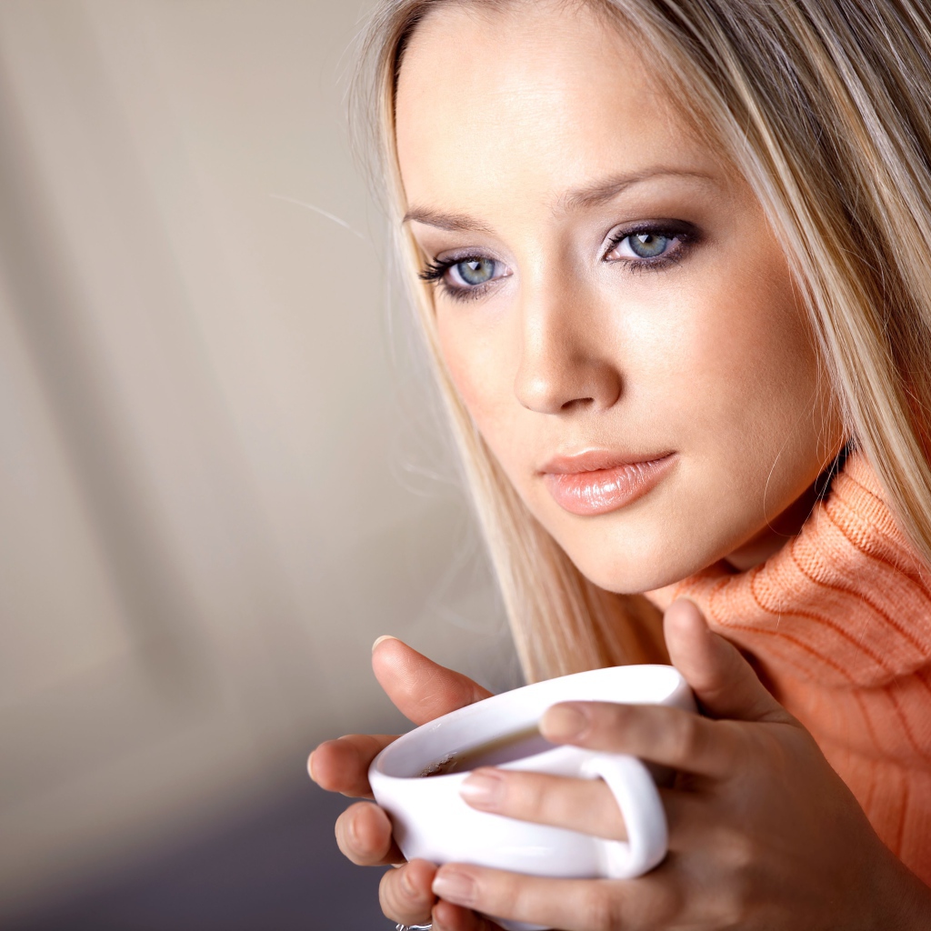 Красивая голубоглазая девушка с чашкой кофе 