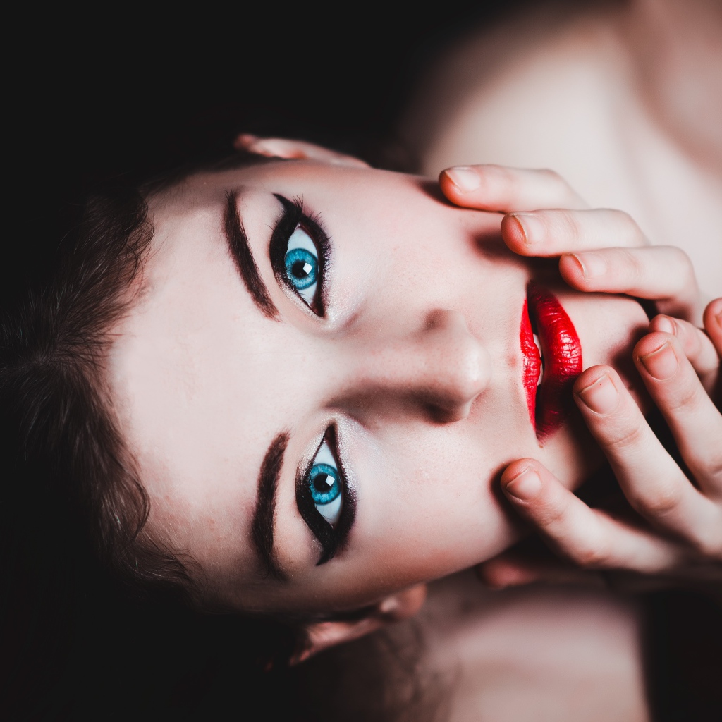 Красивая голубоглазая девушка с красными губами смотрит вверх 