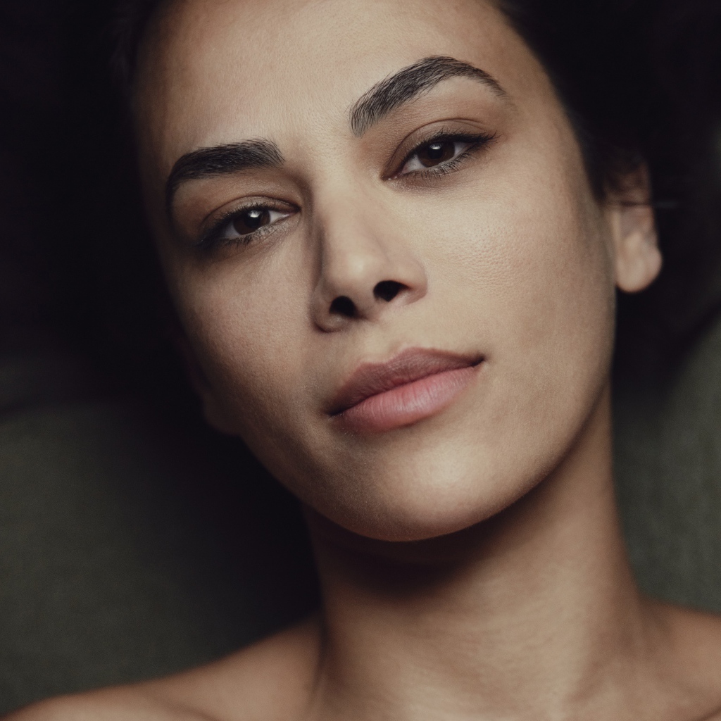 Красивая кареглазая девушка лежит на диване 