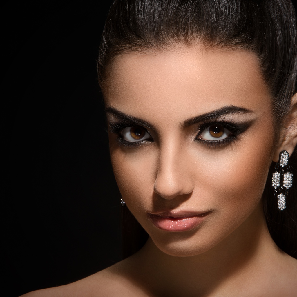 Красивая кареглазая девушка с прической на черном фоне