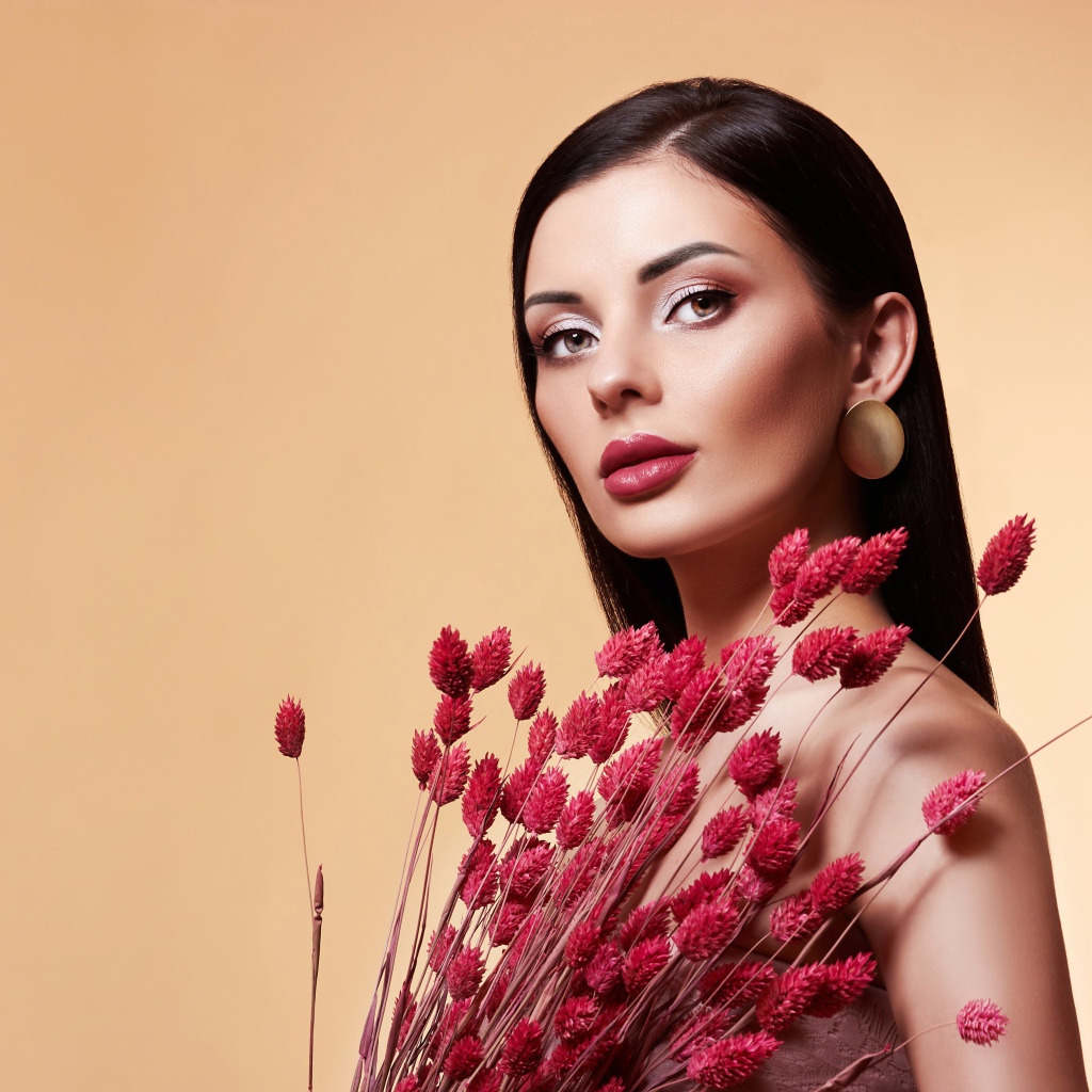 Красивая брюнетка в букетом красных цветов 