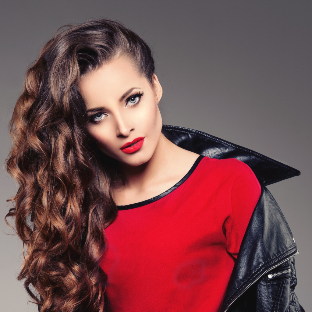 Красивая девушка в черной кожаной куртке и красном свитере