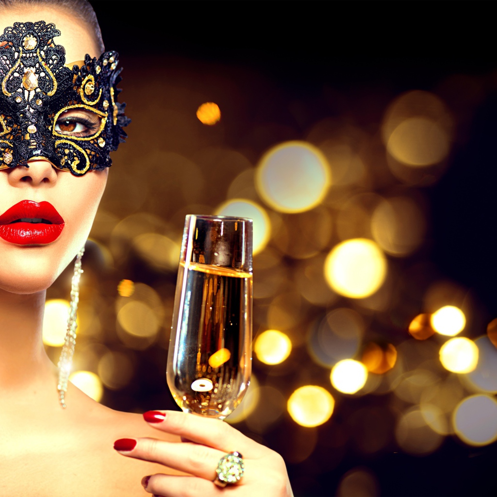 Красивая девушка в черной маске с бокалом шампанского