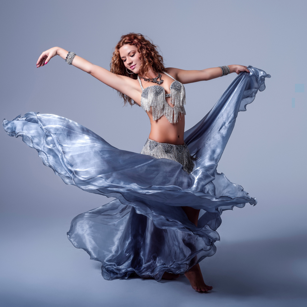 Красивая девушка в платье для танцев на сером фоне