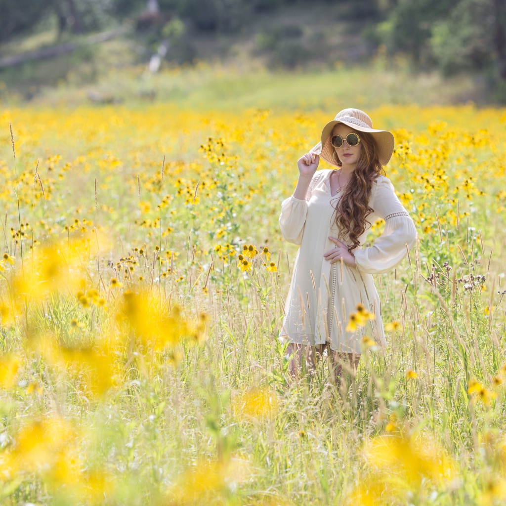 Красивая девушка в шляпе на поле с желтыми цветами